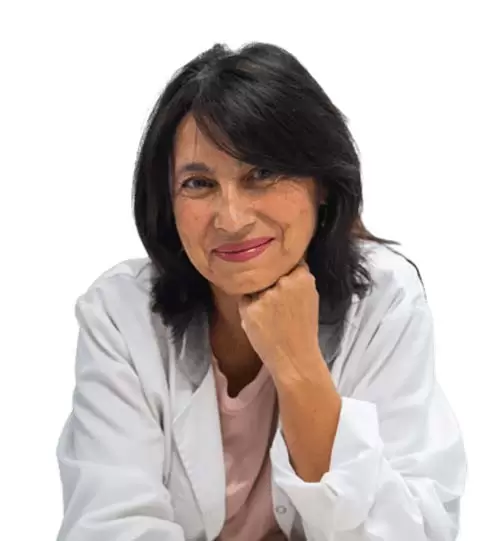 Dra Maria Isabel Ruiz Ruiz posando frente a la cámara con bata blanca, jersey rosa, pelo negro de media melena que le cae sobre un ojo y apoyando la mano en la barbilla mientras sonríe